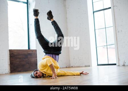 homme en chapeau, petit déjeuner sur le sol en studio de danse Banque D'Images