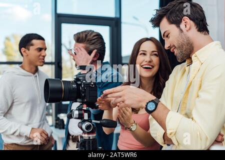 mise au point sélective de collaborateurs heureux à proximité d'un appareil photo numérique Banque D'Images