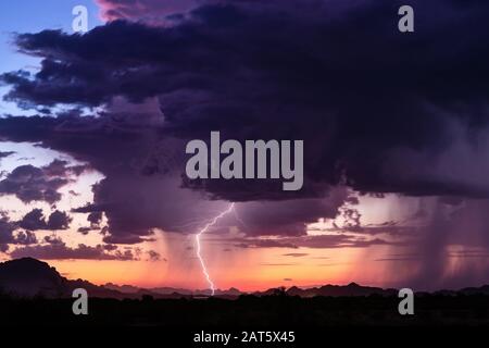 La foudre frappe d'un orage au coucher du soleil dans le désert près de Tonopah, Arizona Banque D'Images