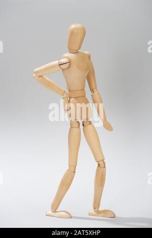 Poupée en bois avec main sur la hanche sur fond gris Banque D'Images