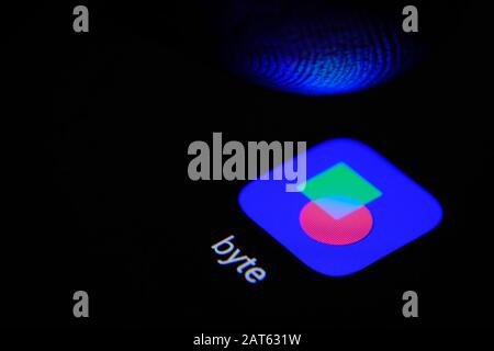 Icône de l'application BYTE sur l'écran tactile et doigt au-dessus. BYTE est une nouvelle plate-forme vidéo de réseaux sociaux. Banque D'Images