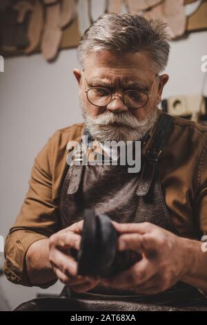 chaussure pavée senior en atelier pour la réparation des chaussures Banque D'Images