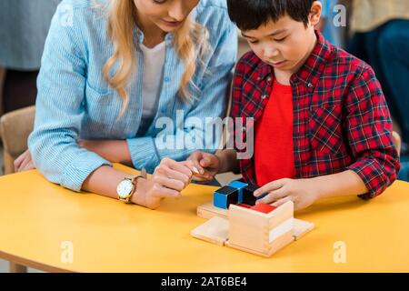 Enfant asiatique jouant des blocs de construction par professeur dans la classe montessori Banque D'Images