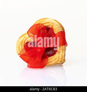 Cookies en forme de coeur attachés avec un arc rouge isolé sur fond blanc. Concept de Saint-Valentin ou d'anniversaire. Banque D'Images