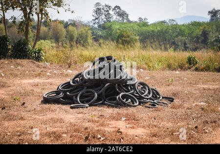 Pneus anciens sur la décharge d'herbe / industrielle pour le traitement des pneus usagés et des pneus en caoutchouc pile de pneus et roues anciens pour le recyclage des pneus en caoutchouc Banque D'Images