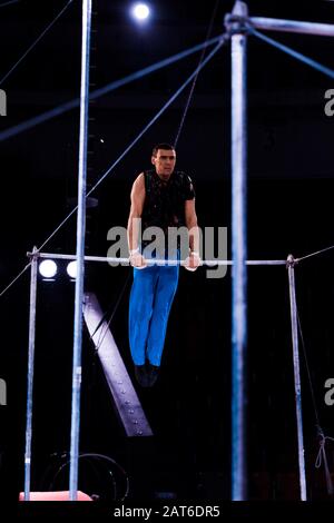 foyer sélectif de beau et de forte gymnast se exécutant sur des barres horizontales dans l'arène du cirque Banque D'Images