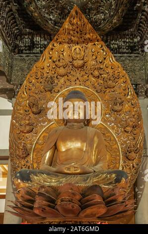 Kaneohe, Oahu, Hawaï, États-Unis. - 11 janvier 2020: Gros plan du Bouddha d'or dans la statue de lotus position dans le temple bouddhiste de Byodo-In avec toile de fond et baldac Banque D'Images