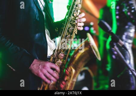 Vue de concert d'un saxophone avec chanteur et groupe musical de jazz en arrière-plan Banque D'Images