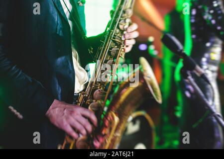 Vue de concert d'un saxophone avec chanteur et groupe musical de jazz en arrière-plan Banque D'Images