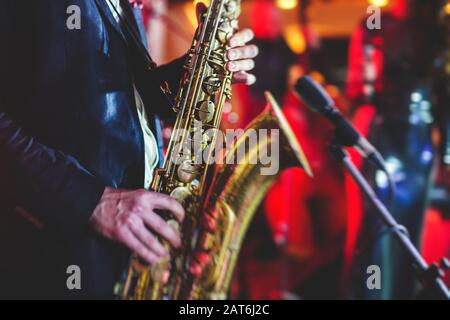 Vue de concert d'un saxophone avec chanteur et groupe musical de jazz en arrière-plan Banque D'Images