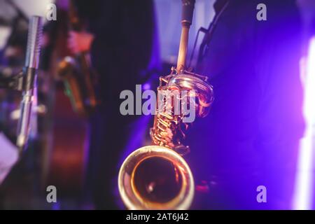 Vue de concert d'un saxophone avec chanteur et groupe musical de jazz en arrière-plan Banque D'Images