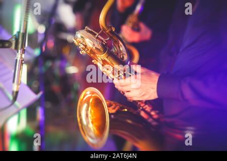 Vue de concert d'un saxophone avec chanteur et groupe musical de jazz en arrière-plan Banque D'Images