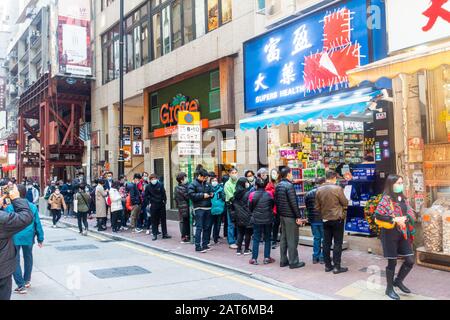 Hong Kong - 30 janvier 2020: Les gens se line à la pharmacie pour acheter des masques chirurgicaux dans la peur de Wuhan Coronavirus Banque D'Images