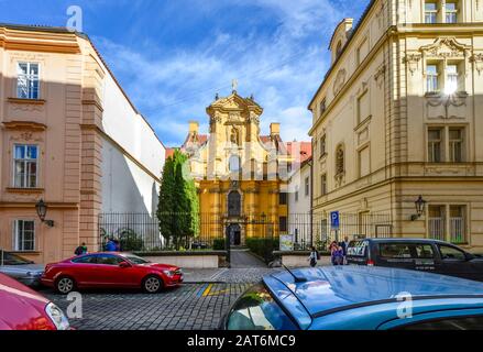 L'église Saint-Joseph de Mala Strana avec une cour clôturée est comprimée entre deux nouveaux bâtiments de la section de la petite ville de Prague, République tchèque. Banque D'Images