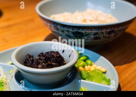 Zhajiangmian (nouilles chinoises avec sauce aux haricots de soja et avec tous les types de plat latéral) sur la table. C'est le roi du plat traditionnel de Pékin Banque D'Images