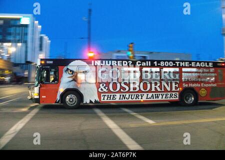 Tucson Sun Tran bus en mouvement avec les deux côtés peints au-dessus y compris les portes et les fenêtres à l'exception des conducteurs avec la publicité géante pour les avocats de cabinet de blessures Banque D'Images