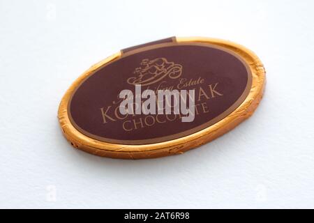 Magadan, Russie - Janvier 2020. Chocolat Kopi Luwak enveloppé dans une feuille d'or. Célèbre bonbons à café isolé sur fond blanc. Logo civet Banque D'Images