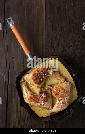 Pattes de poulet frit dans une poêle, style rustique, vue sur le dessus Banque D'Images