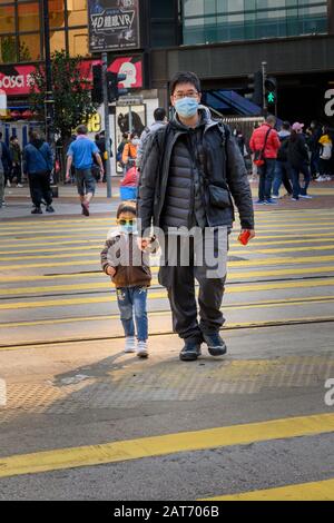 Causeway Bay Hong Kong. 30 janvier 2020. Un homme et un jeune garçon de Causeway Bay portent des masques de protection contre le virus corona. L'Organisation mondiale de la santé a annoncé l'éclosion en Chine d'une urgence sanitaire mondiale, Banque D'Images