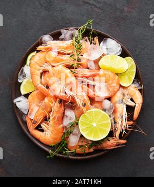 Crevettes servi de citrons et d'épices sur un fond noir Banque D'Images