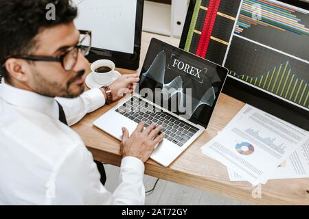 point de mire sélectif du commerçant biracial utilisant un ordinateur portable avec des lettres forex Banque D'Images