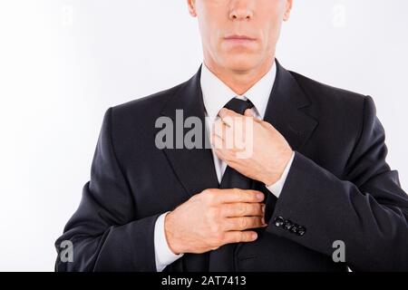 Gros plan photo de l'homme en costume fixant sa cravate Banque D'Images
