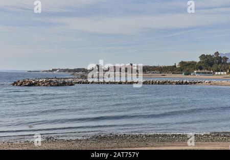 Plage avec brise-lames à Marbella, journée d'été avec sable et vagues Banque D'Images