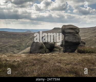 Magnifique paysage de formations rocheuses dans une terre herbeuse entourée par de belles montagnes Banque D'Images