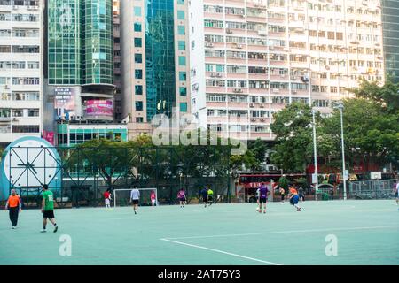 Hong Kong - février 2020: Les gens qui font de l'exercice de jouer au football dans l'aire de jeux publique de WAN Chai Banque D'Images