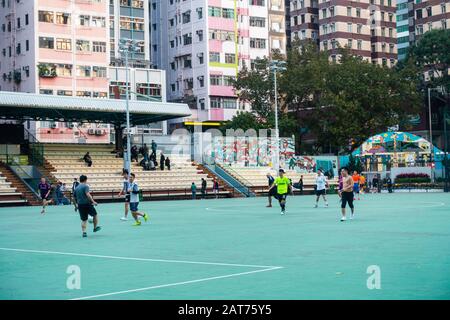 Hong Kong - février 2020: Les gens qui font de l'exercice de jouer au football dans l'aire de jeux publique de WAN Chai Banque D'Images