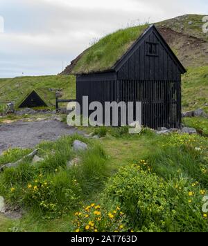 Village de pêcheurs typique islandais avec maisons au toit d'herbe et séchage du poisson portoirs Banque D'Images