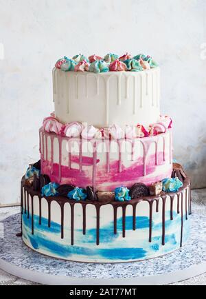 Gâteau de couleur à trois niveaux avec des taches de chocolat colorées sur un fond clair. Photo pour un menu ou un catalogue de confiseries, le gâteau de mariage Banque D'Images