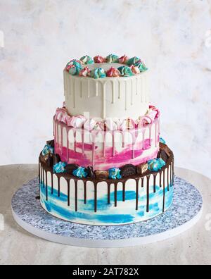 Gâteau de couleur à trois niveaux avec des taches de chocolat colorées sur un fond clair. Photo pour un menu ou un catalogue de confiseries, le gâteau de mariage Banque D'Images