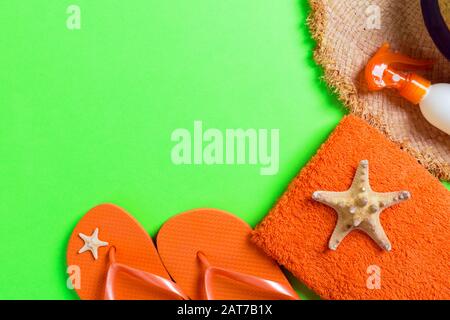 Été plage télévision jeter accessoires. Bouteille d'écran solaire crème, chapeau de paille, tongs, serviette et coquilles sur fond de couleur. Concept de vacances voyage wi Banque D'Images