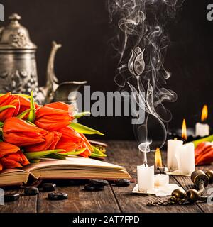 Tulipes orange sur le vieux livre Banque D'Images