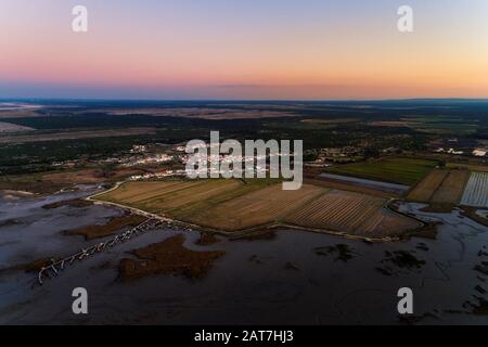 Vue aérienne du village de Carapateira avec l'estuaire du Sado, la jetée palafitique et les rizières environnantes, au Portugal Banque D'Images