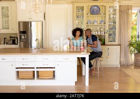 Un jeune couple heureux assis à la table dans la cuisine Banque D'Images