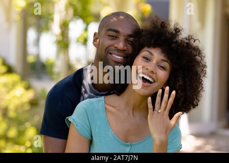 Un jeune couple heureux avec une femme montrant son anneau de mariage Banque D'Images