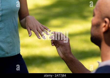 Jeune homme faisant la proposition de mariage dans le jardin Banque D'Images