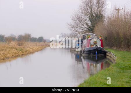 Des bateaux à Narrowboats amarrés sur le côté du canal d'Oxford en hiver Banque D'Images