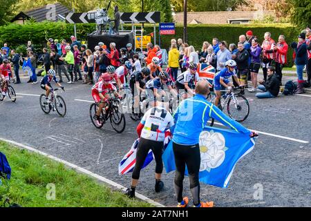 Les cyclistes de course sur route (peloton) qui se livrent à des courses de vélo ont été acclamé par des supporters qui ont fait du drapeau - UCI World Championships, Harrogate, GB UK Banque D'Images