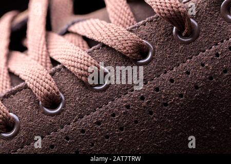 Partie d'une chaussure en daim avec lacets. Un fragment de chaussures brunes. Un morceau de sneaker. Banque D'Images