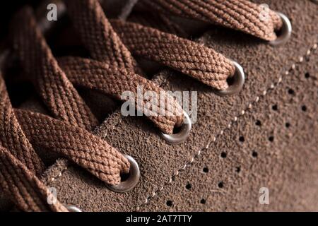 Partie d'une chaussure en daim avec lacets. Un fragment de chaussures brunes. Un morceau de sneaker. Banque D'Images