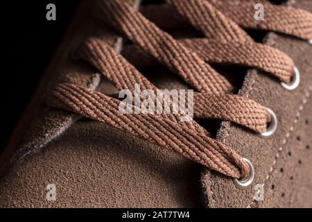 Partie d'une chaussure en daim avec lacets. Un fragment de chaussures brunes. Un morceau de sneaker. Banque D'Images