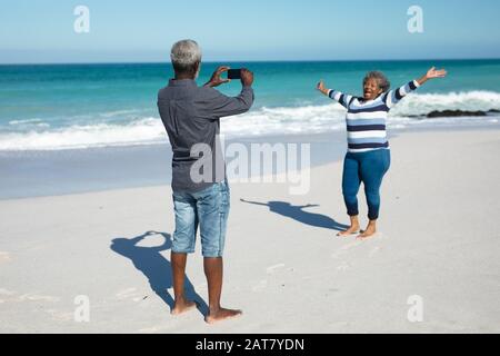 Un vieux couple prend des photos à la plage Banque D'Images