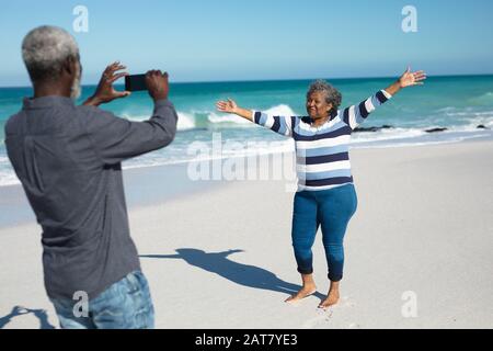 Un vieux couple prend des photos à la plage Banque D'Images