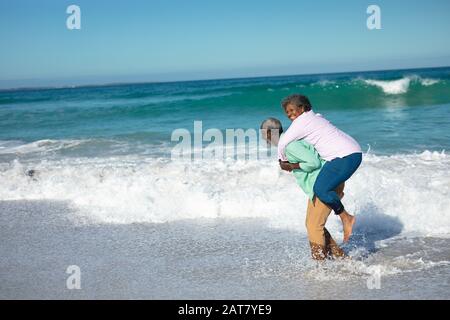 Un vieux couple s'amuser à la plage Banque D'Images