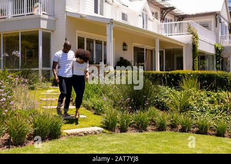 Jeune couple marchant dans le jardin Banque D'Images