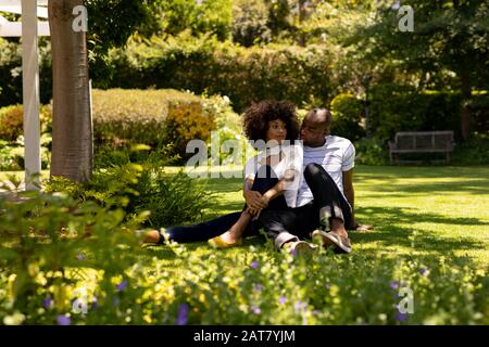 Un couple jeune et heureux se détendant dans le jardin Banque D'Images