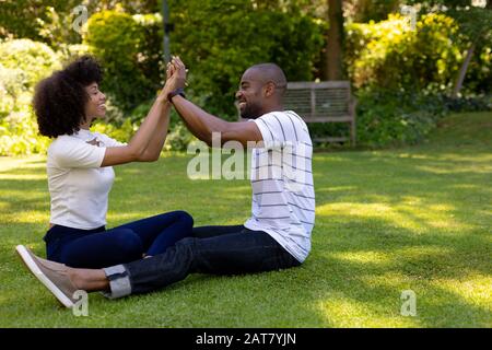 Un couple jeune et heureux se détendant dans le jardin Banque D'Images